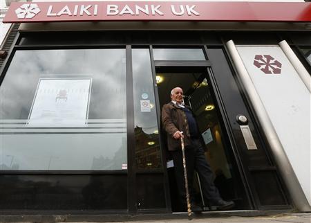 A customer walks out of a branch of Laiki Bank UK, in north London